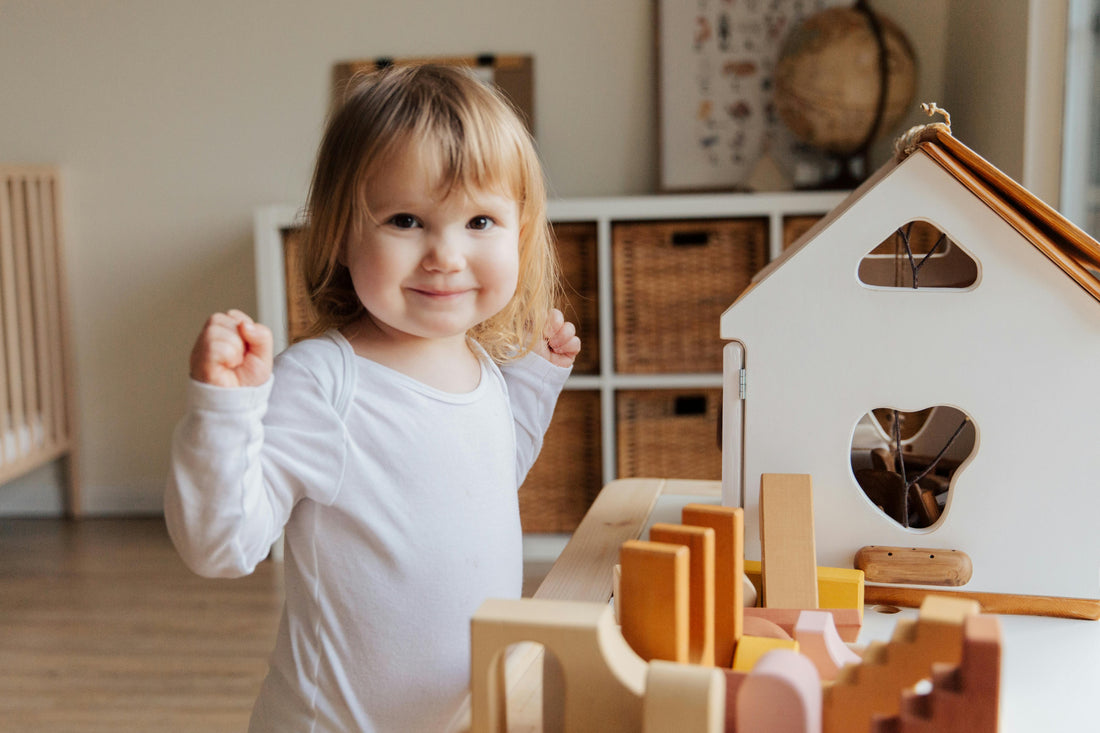 Petite fille jouant avec des jouets en bois dans un espace Montessori, favorisant le développement de l'enfant par le jeu libre